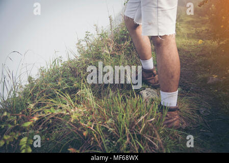 foot of young Man Traveler with backpack relaxing outdoor with rocky mountains on background Summer vacations and Lifestyle hiking concept. Stock Photo