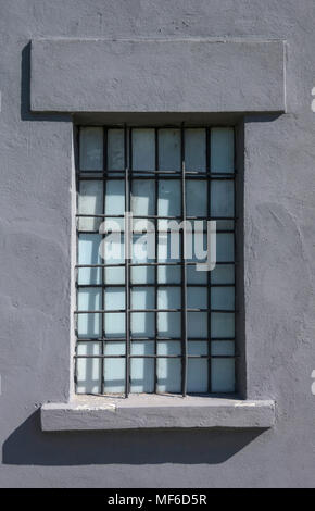 NIS, SERBIA - APRIL 21, 2018: Old gray prison window with metal bars. History concept Stock Photo