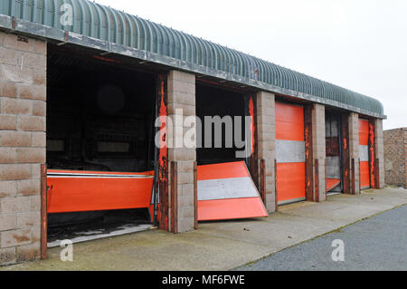 Derelict fire station garage with doors broken blow in Stock Photo