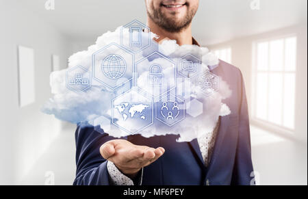 Businessman holding cloud with different digital icons. Stock Photo