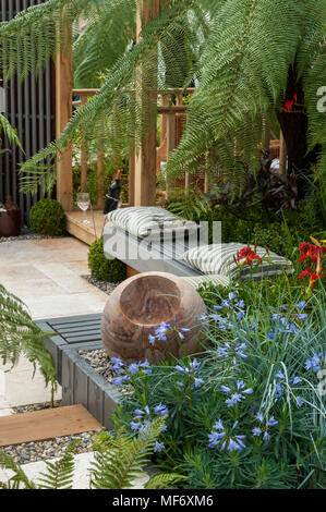 Exotic palms, gazebo, stone ornament & flowers in tropical style show garden - Visit Plantation: Colonial Chic and Bajan Roots. RHS Show Tatton Park. Stock Photo