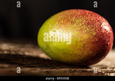 Whole mango on a dark wood background Stock Photo