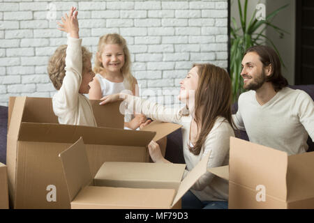 Happy boy jumping from box playing with family packing together Stock Photo