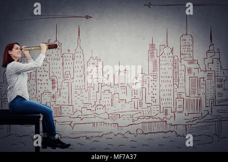 Portrait of positive, young woman looking through a spyglass at an imaginary drawn city, Ready for a new adventure. Business break, dreaming of holida Stock Photo