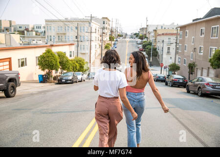 Two young women walking down the street Stock Photo