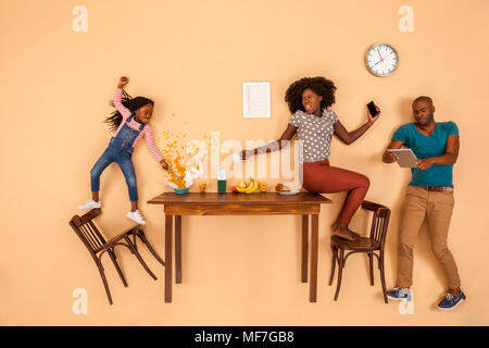 Stressed out family having breakfast in the kitchen, checking mobile devices Stock Photo