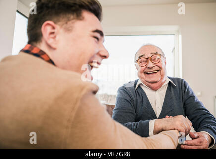 Happy senior man and young man arm wrestling Stock Photo