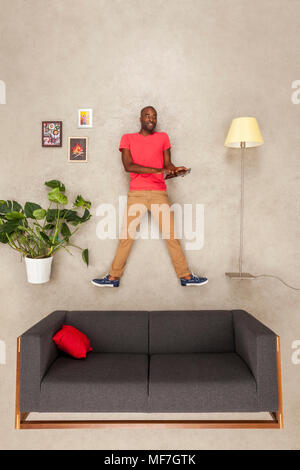 Man at home in his livingroom using tablet Stock Photo