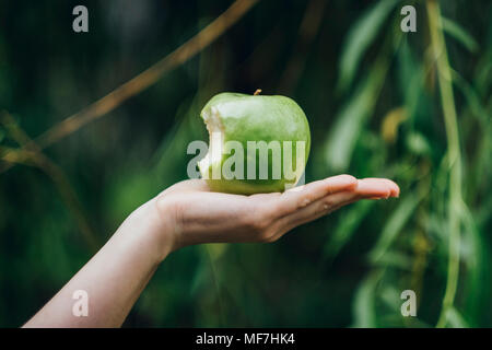 Woman's hand holding bitten apple Stock Photo