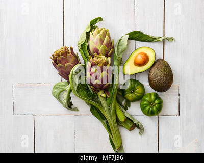 Artichokes, green tomatoes, and sliced and whole avocado Stock Photo