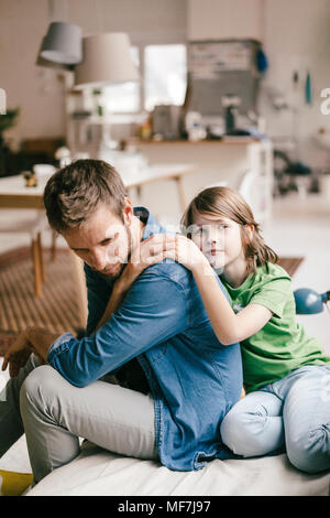 Son consoling sad father at home Stock Photo