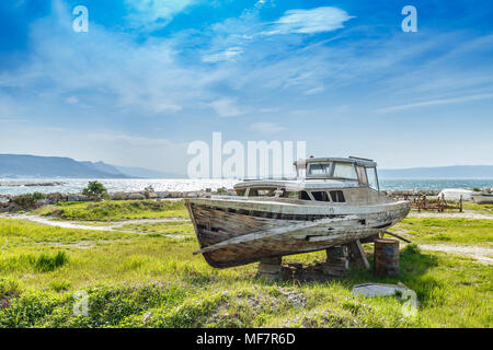 An old shipwreck boat abandoned stand on grass Stock Photo