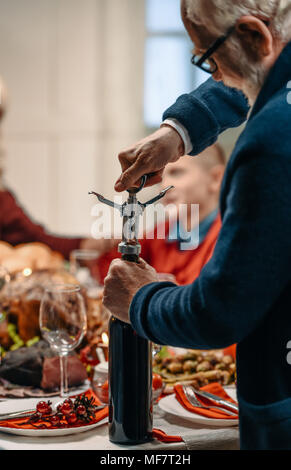 senior man opening bottle of wine Stock Photo