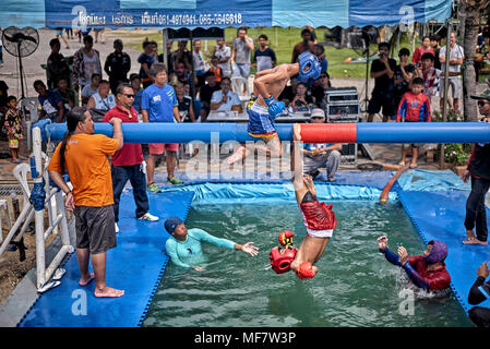 Unusual sport. Muay Thai fighters competing on a Battle Beam perched over water. Thailand Southeast Asia Stock Photo