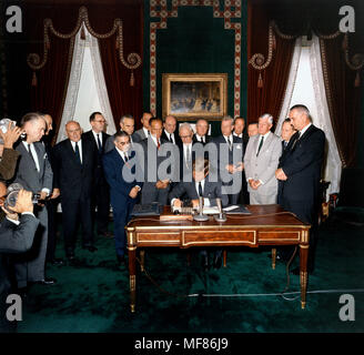 KN-C30095  07 October 1963  President Kennedy signs the Limited Nuclear Test Ban Treaty. William Hopkins, Sen. Mike Mansfield, John J. McCloy, Adrian S. Fisher, Sen. John Pastore, W. Averell Harriman, Sen. George Smathers, Sen. J.W. Fulbright, Sec. of State Dean Rusk,  Sen. George Aiken, President Kennedy, Sen. Hubert H. Humphrey,  Sen. Everett Dirksen, William C. Foster, Sen. Howard W. Cannon, Sen. Leverett Saltonstall, Sen. Thomas H. Kuchel, Vice President Johnson. White House, Treaty Room. Photograph by Robert Knudsen, White House, in the John F. Kennedy Presidential Library and Museum, Bos Stock Photo