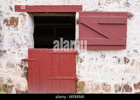 Old Red Door on Whitewashed Stone Barn Stock Photo