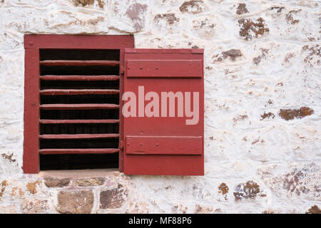 Old Red Window Vent on Whitewashed Stone Barn Stock Photo