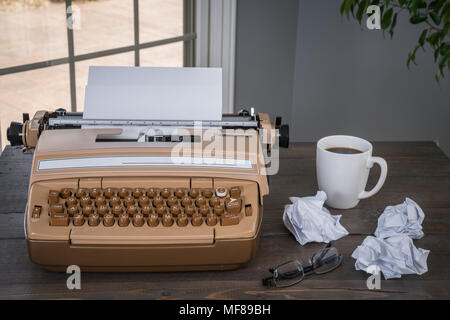 Old Vintage Typewriter on a Wood Desk with Coffee and Paper Stock Photo