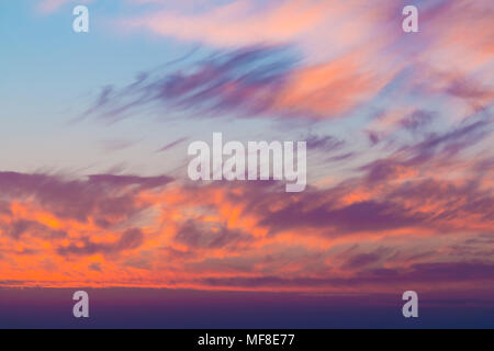 Beautiful cloudscape at scarlet sunset with colorful contrasting cirrus clouds Stock Photo