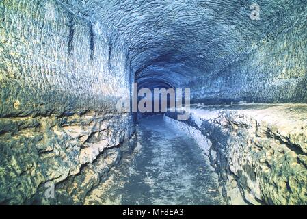 The old sandstone water tunnel, mined caves.  The cave. Sandstone tunnel moistened walls. Dry channel carved in the rocky underground Stock Photo