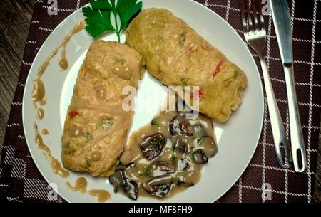 Tasty food, nutrition, kitchen and culinary concept: stuffed cabbage rolls with rice and chicken meat in forest mushroom sauce. Stock Photo