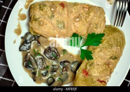 Tasty food, nutrition, kitchen and culinary concept: stuffed cabbage rolls with rice and chicken meat in forest mushroom sauce. Stock Photo