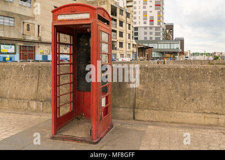Ipswich, Suffolk, England, UK - May 27, 2017: Empty telephone booth without door on Bridge Street with the buildings of Ipswich Waterfront