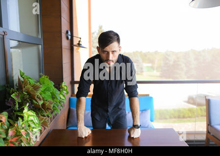Young businessman standing at office and wearing black shirt. Stock Photo