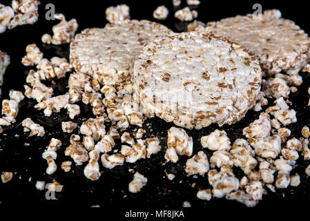 Wheat grain crispbread on black background, diet eating, in low key Stock Photo