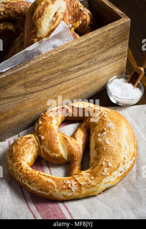Pretzel with Sea Salt on Rustic Wooden Background Stock Photo