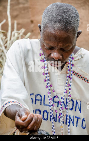 African voodoo priest looking down concentrated while performing religious ritual Stock Photo