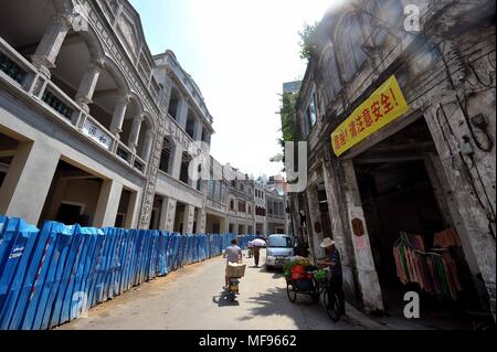 (180425) -- HAIKOU, April 25, 2018 (Xinhua) -- File photo taken on Aug. 14, 2012 shows the Qilou buildings in Haikou, capital of south China's Hainan Province. Nanyang-style Qilou buildings are balcony-type tenant buildings for both residential and commercial use. The first floor of a Qilou house is used as a shop, and part of the second floor hangs over the first floor and is supported by columns, forming a shelter in front of the shop. People live on the upper floors. Qilou houses line up to form a shopping street, leaving overhangs on both sides of the street to shelter pedestrians. (Xinhua Stock Photo