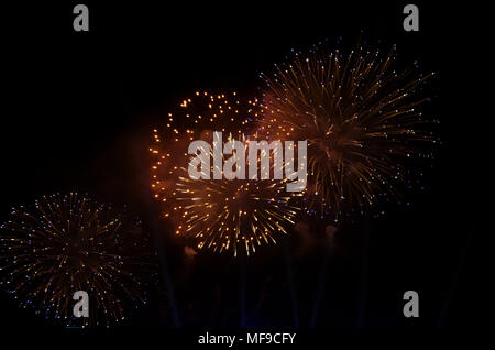 Colorful fireworks and smoke against a black sky as background. Stock Photo