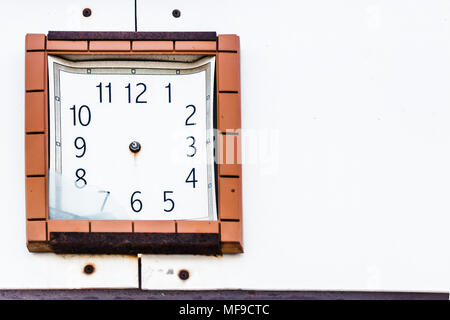 rusty, old broken clock, without arrows on a light wall with space for text Stock Photo