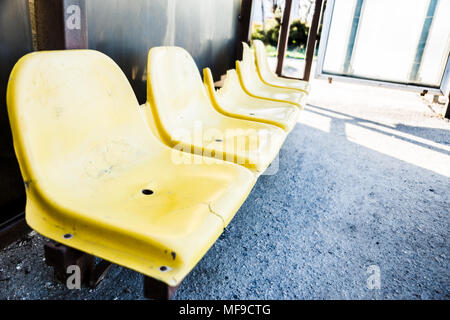 damaged yellow chairs at the bus stop, close-up, background image with space for text Stock Photo