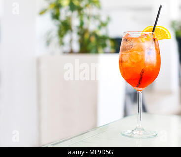 Orange alcohol cocktail with straw on white table Stock Photo