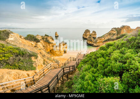 Beautiful Camilo Beach with wooden walkway descending to the sandy beach in Lagos, Algarve, Portugal Stock Photo