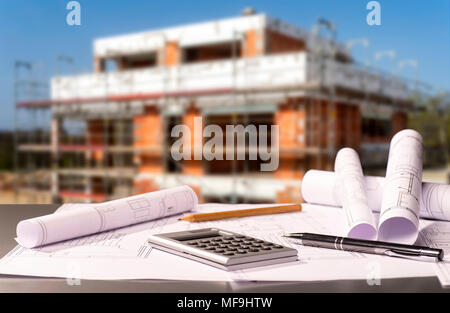 Construction plans with calculator and a shell in the background Stock Photo