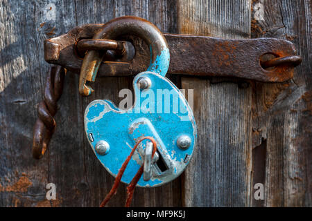 Padlock on the garage door. Gate locked on the castle. Vintage, old.Door hinges. closed. Storage room, garage, hangar.open lock, door breaking Stock Photo