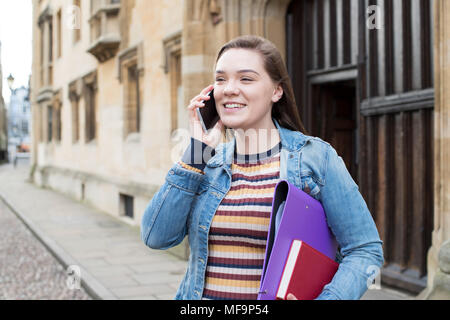 Female Student Talking On Mobile Phone Outside College Building Stock Photo