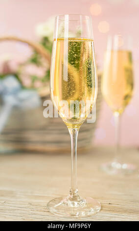 2 champagne glasses in front of spring flowers in pastel colored surroundings Stock Photo