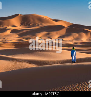 A Berber Man stands at the edge of the Sahara Desert, Erg Chebbi, near Merzouga, Morocco MODEL RELEASED Stock Photo