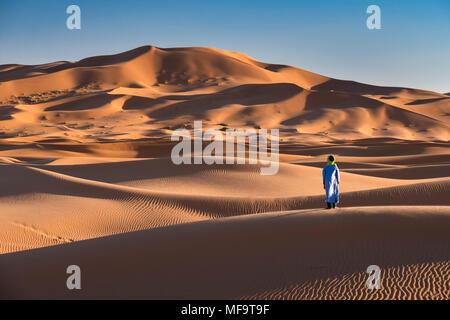 A Berber Man stands at the edge of the Sahara Desert, Erg Chebbi, near Merzouga, Morocco MODEL RELEASED Stock Photo
