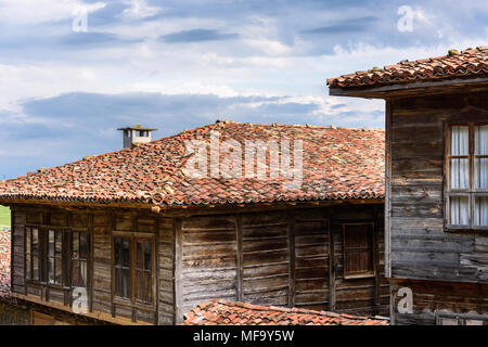 Zheravna, Bulgaria - Two authentic rustic house made of stone and wood with tile roofs against the cloudy sky Stock Photo