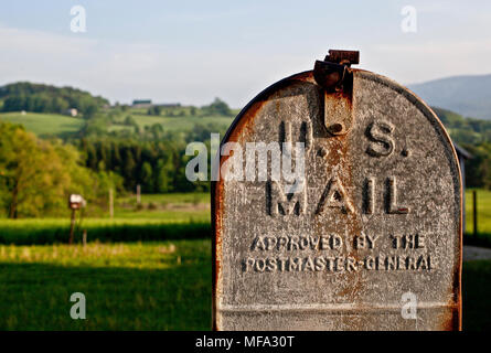 classic old rusted mailbox on a Vermont farm in front of a beautiful summer meadow Stock Photo