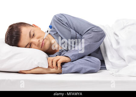 Sick teenager with a thermometer in his mouth lying in bed isolated on white background Stock Photo