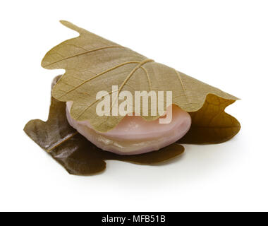 kashiwa mochi is white mochi surrounding a sweet anko filling with a kashiwa oak leaf wrapped around it. Stock Photo