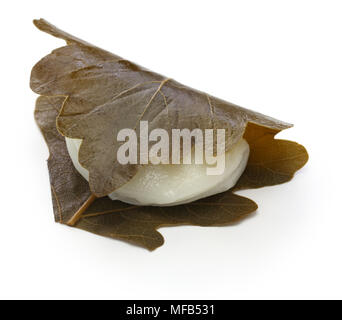 kashiwa mochi is white mochi surrounding a sweet anko filling with a kashiwa oak leaf wrapped around it. Stock Photo