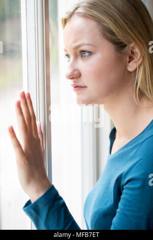 Sad Young Woman Suffering From Depression Looking Out Of Window Stock Photo