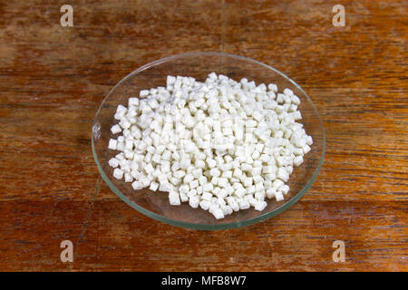 A watch glass containing small nylon 6/6 pieces as used in a UK Secondary/High school. Stock Photo